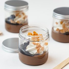Budino al cioccolato con topping al cacao, chips di caramello e panna montata