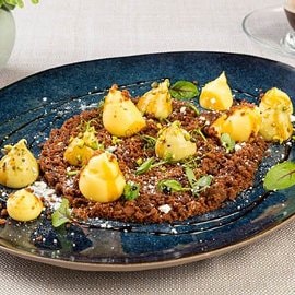 Tiramisù al pistacchio, terra al cacao e salsa al vincotto (terramissù) con germogli di erbette