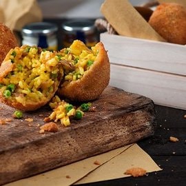 Arancino di riso alla curcuma con speck e piselli Arancino di riso alla curcuma con speck e piselli