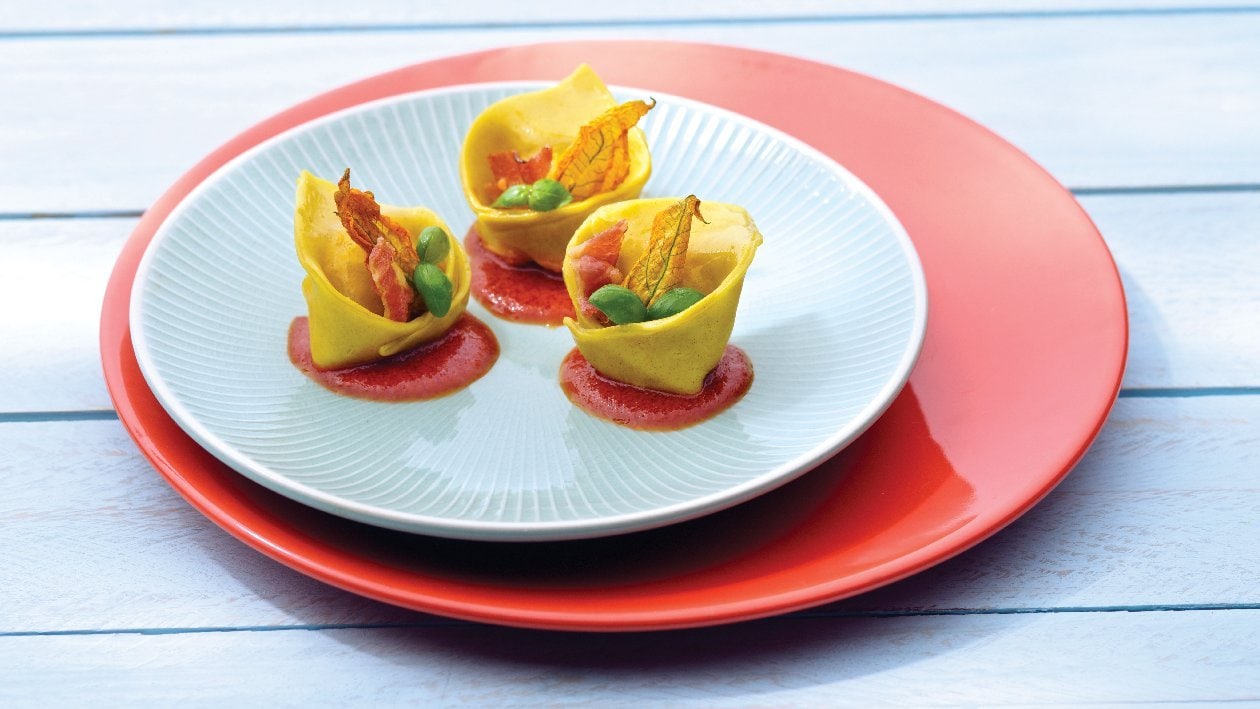 Cappellacci ripieni con ricotta, fiori di zucca, pancetta disidratata su coulis di pomodoro e origano – - Ricetta