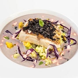 Filetto di dentice con cavolo romanesco, su crema di patate viola, Caesar dressing e polvere di olive Filetto di dentice con cavolo romanesco, su crema di patate viola, Caesar dressing e polvere di olive