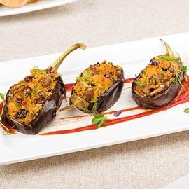 Melanzane ripiene di quinoa con funghi, salsiccia e olive