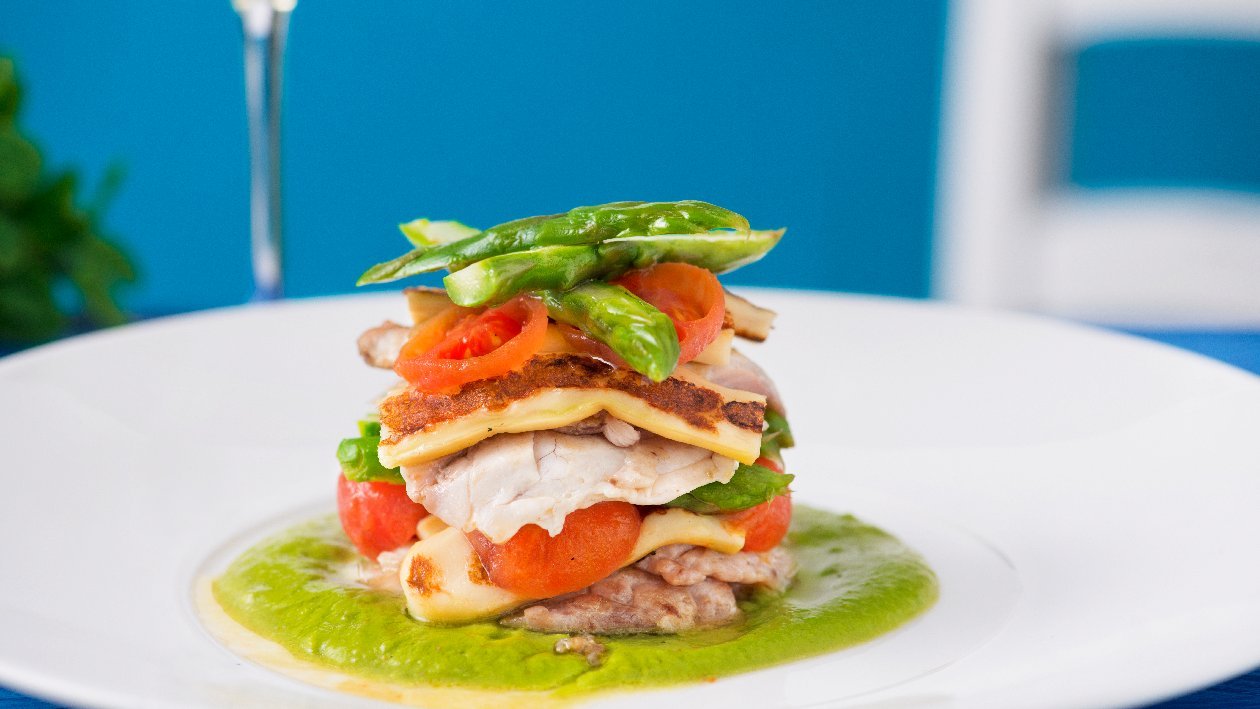 Parmigiana di spigola con pomodoro confit, provola affumicata si crema di asparagi e chips di carote – - Ricetta