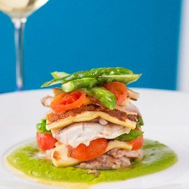 Parmigiana di spigola con pomodoro confit, provola affumicata si crema di asparagi e chips di carote Parmigiana di spigola con pomodoro confit, provola affumicata si crema di asparagi e chips di carote