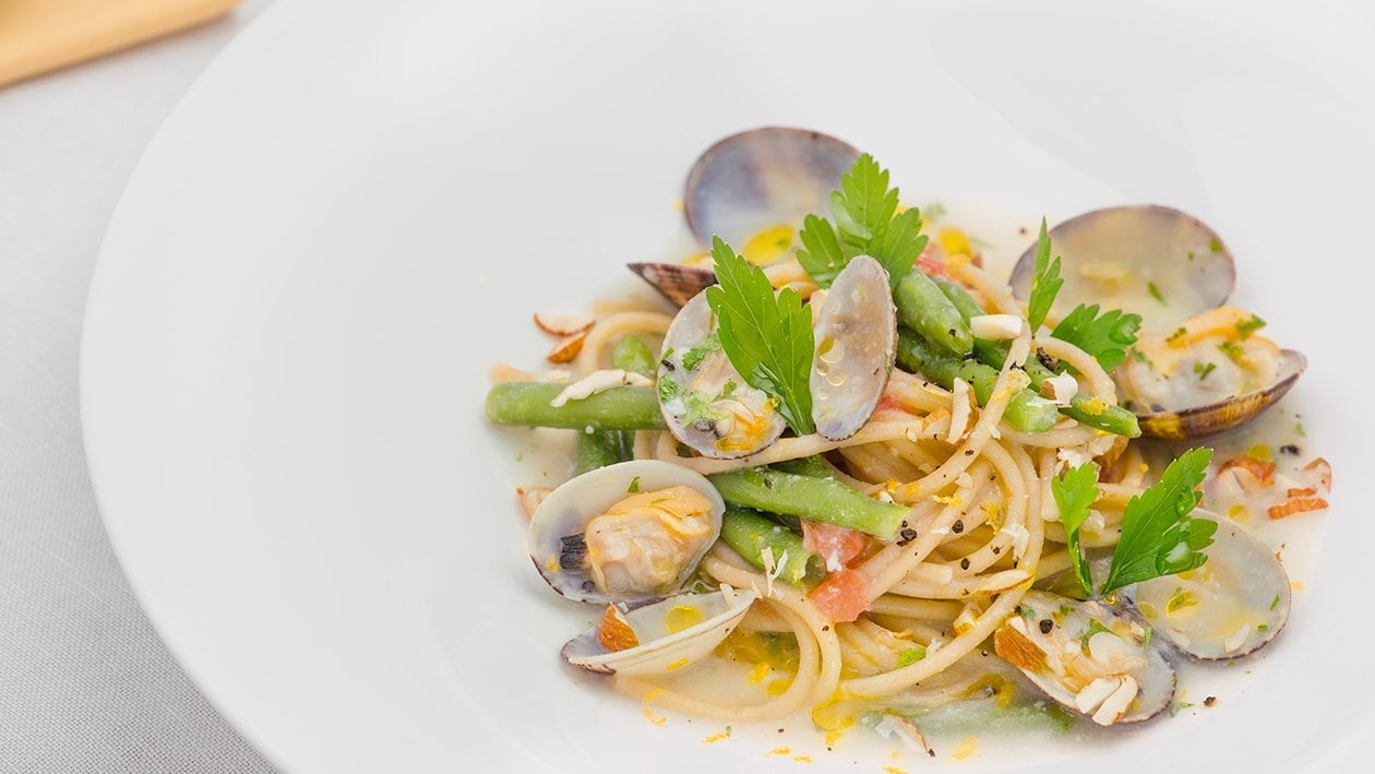 Spaghetti integrali con mandorle, fagiolini e guazzetto di vongole – - Ricetta