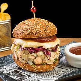 Burger ai semi con hamburger di pollo in crosta di mandorle e sesamo nero, radicchio all'aceto di lamponi, tomino e ketchup al balsamico